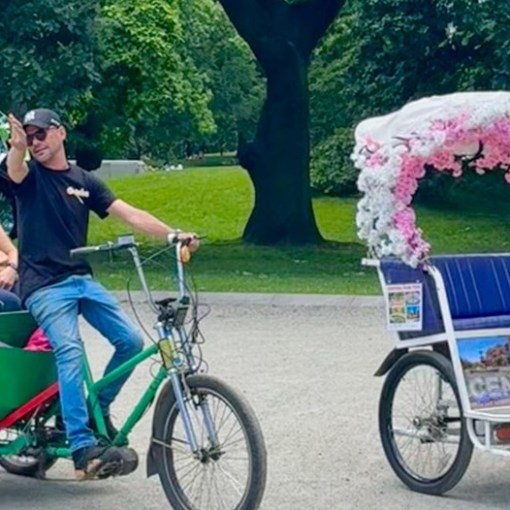 a little girl riding on the back of a bicycle